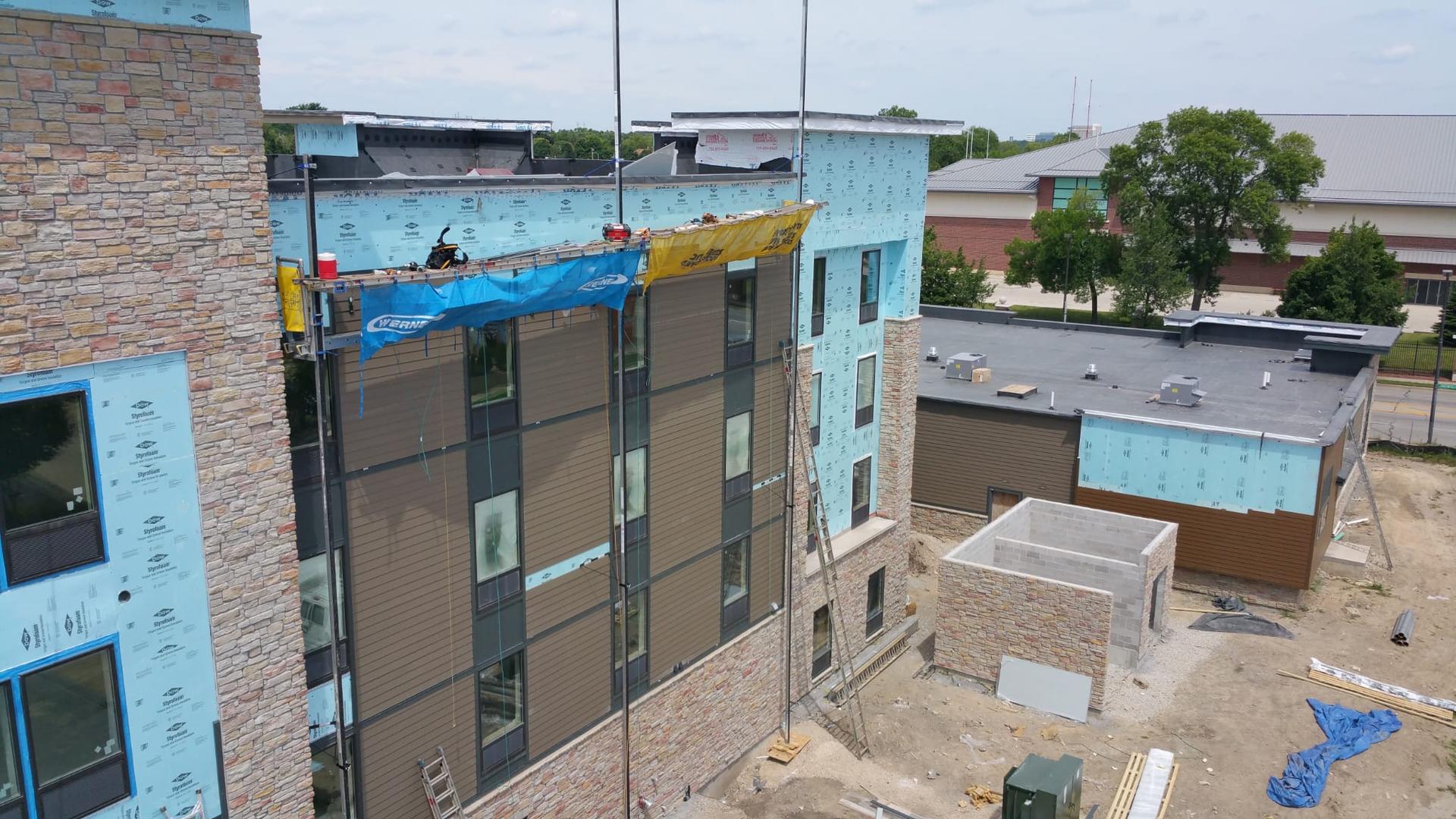 Commercial siding installation with crew on scaffolding