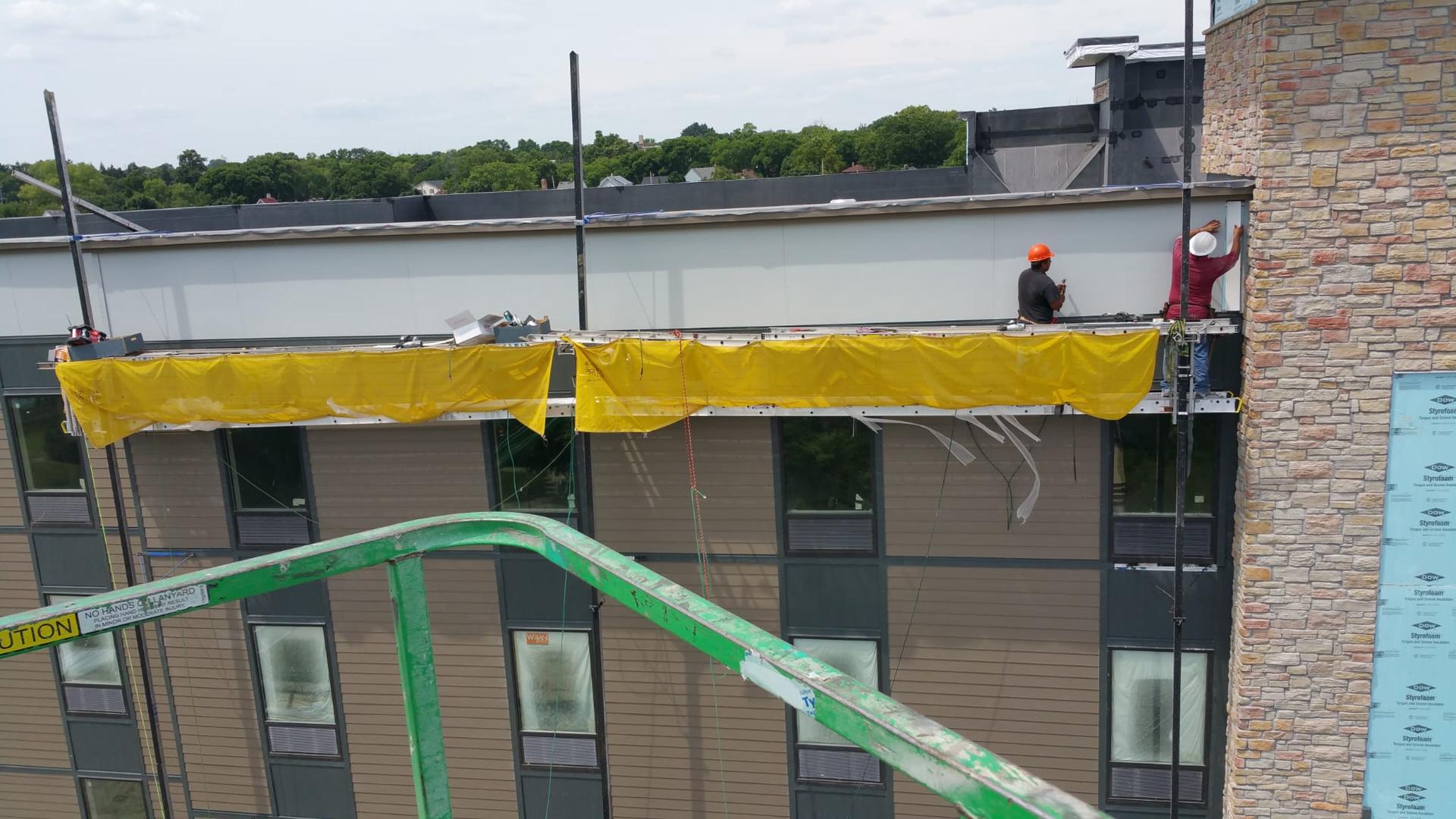 Your Company crew installing siding on a commercial build